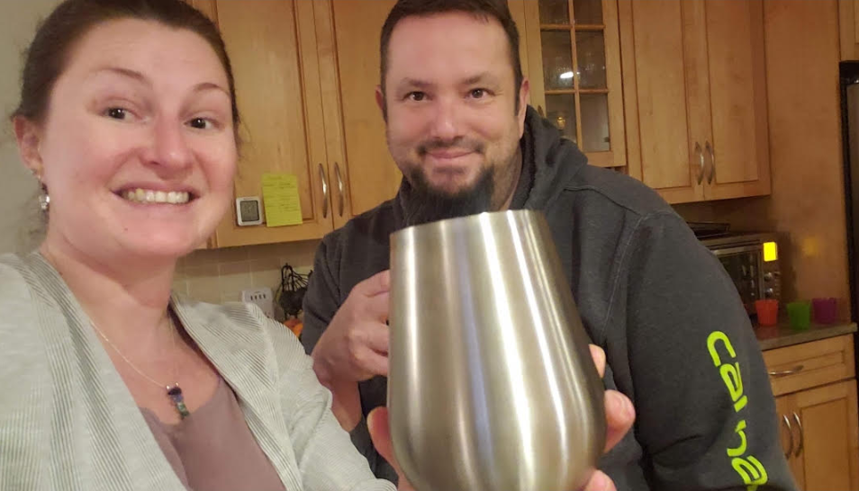 Jami and Craig raising glasses together in the kitchen